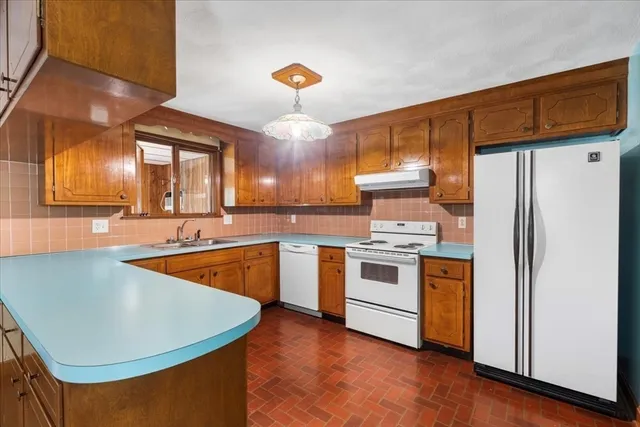 a kitchen with stainless steel appliances granite countertop a sink a stove and refrigerator