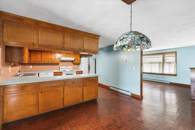 a kitchen with stainless steel appliances granite countertop a sink a stove cabinets and wooden floor