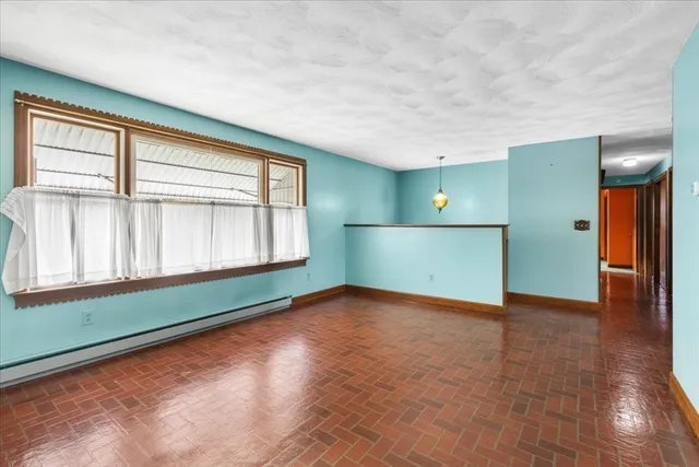 a view of an empty room with window and stairs