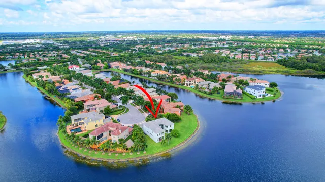 an aerial view of a house with a yard and lake view