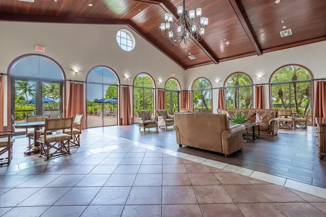 a very nice looking dining room with lots of furniture wooden floor and floor to ceiling window