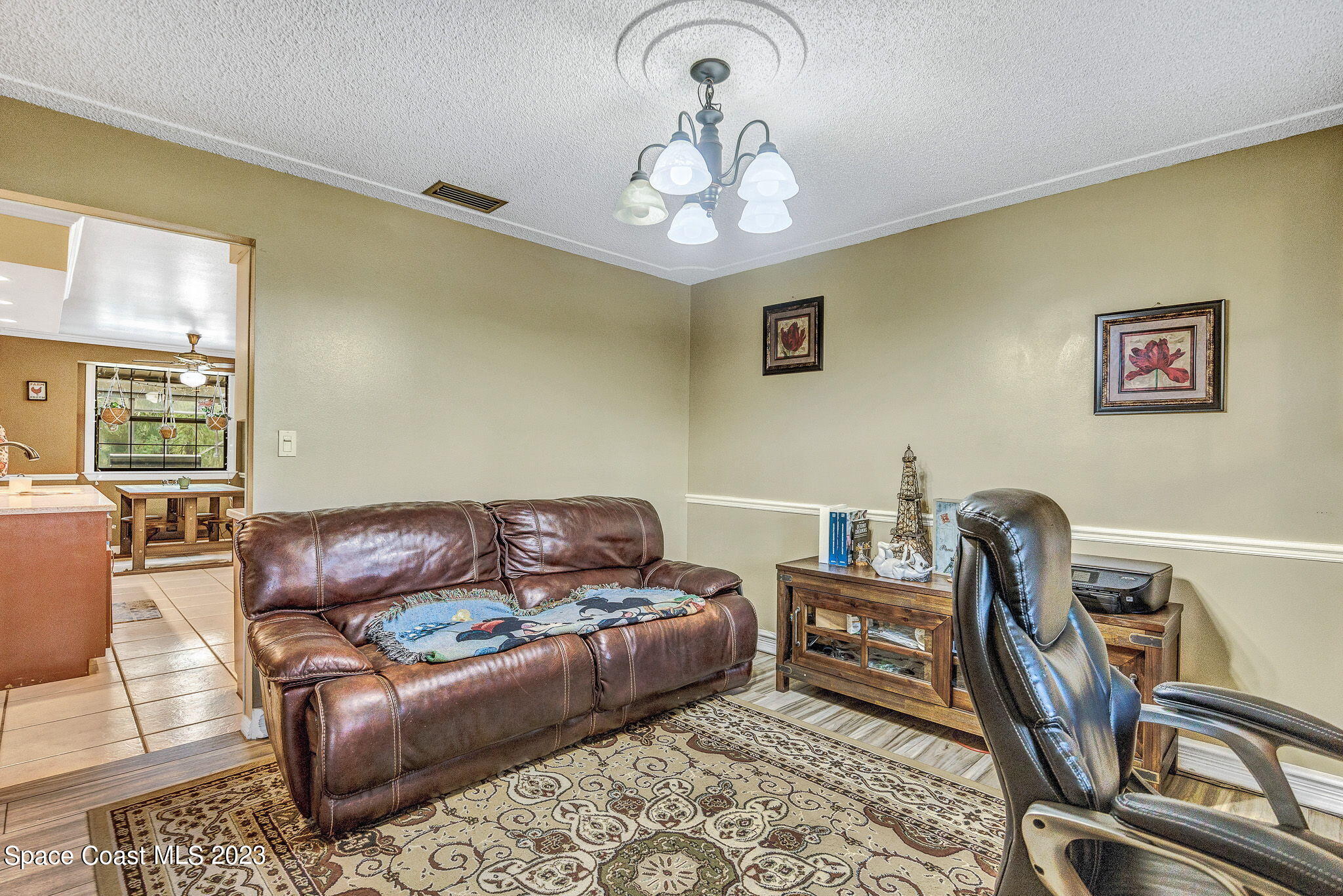 2281 Friday Road Cocoa, FL 32926 - Photo 21 of 72 a living room with furniture a couch and a chandelier