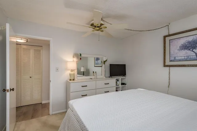 a bedroom with a bed and a flat tv screen on the dresser