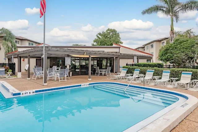 a view of a swimming pool with chairs and tables