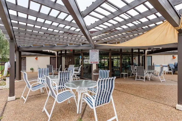 a view of a patio with a table and chairs and a barbeque