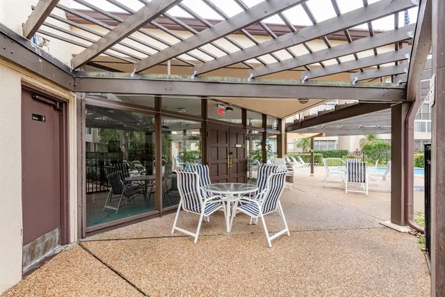 a dining room with furniture water view and a floor to ceiling window