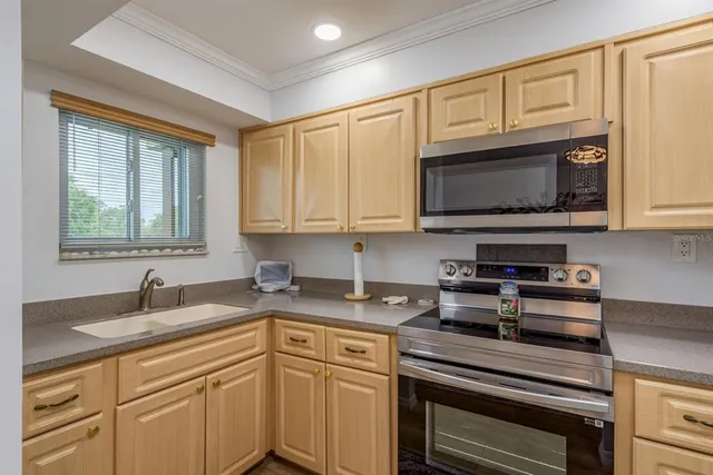 a kitchen with granite countertop cabinets stainless steel appliances and a sink