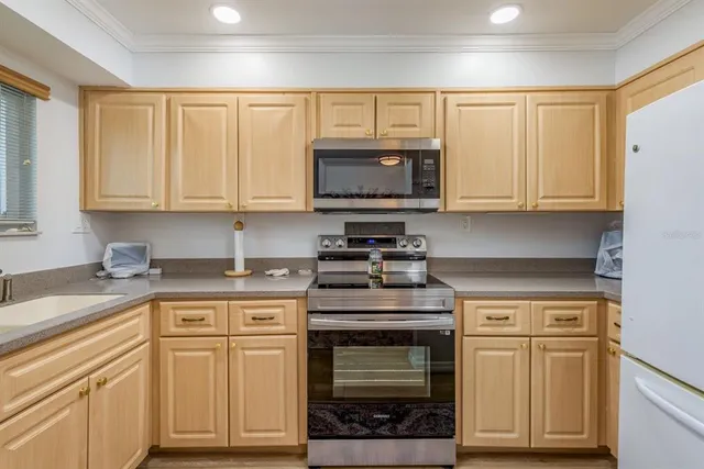 a kitchen with granite countertop cabinets stainless steel appliances and a sink