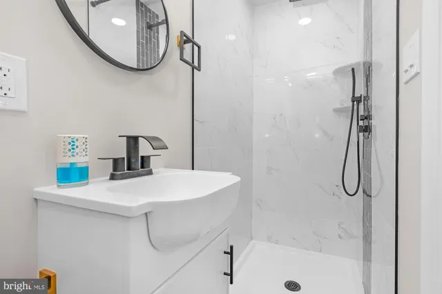 a bathroom with a sink a shower and a mirror