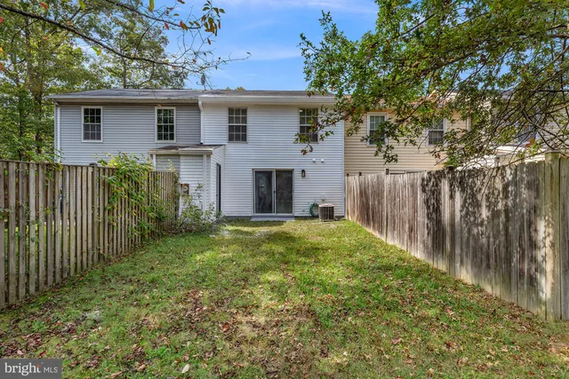 a view of a house with backyard and a tree
