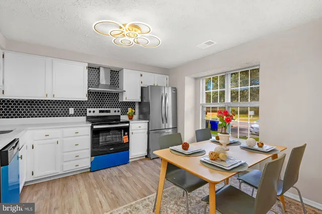 a kitchen with a stove a refrigerator and a dining table