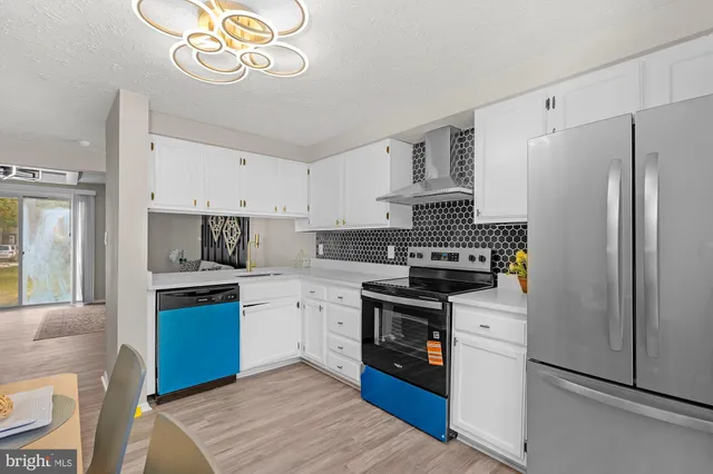 a kitchen with stainless steel appliances granite countertop a refrigerator stove and sink