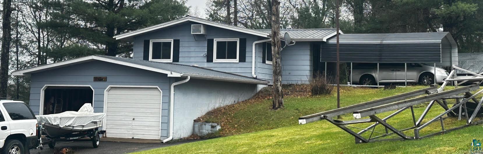 View of front of property featuring a garage and a front lawn