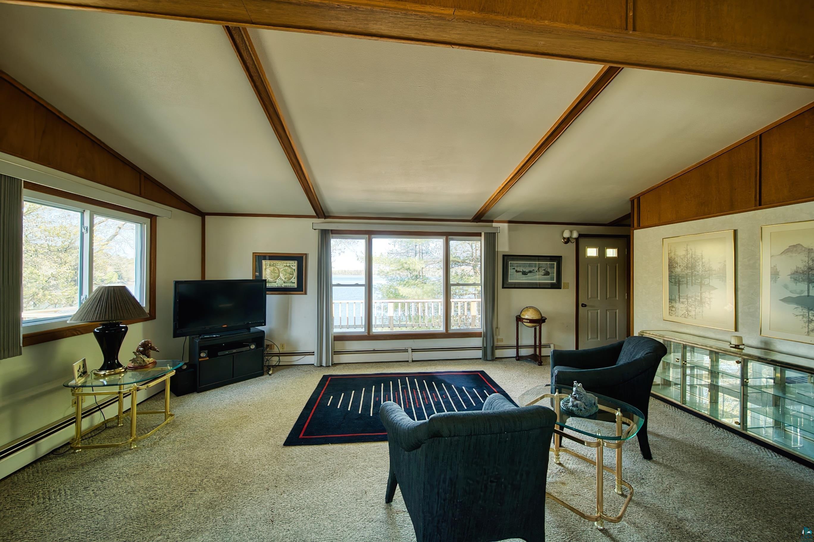 29836 Long Lake Road Danbury, WI 54830 - Photo 9 of 40 Living room with a wealth of natural light, carpet, and vaulted ceiling with beams