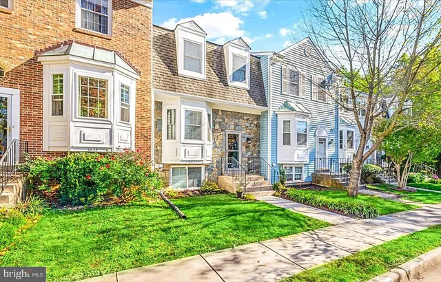 front view of a brick house with a yard