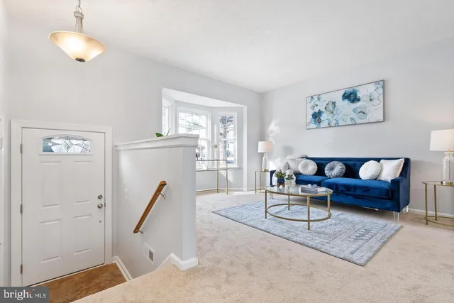 a living room with furniture a window and wooden floor