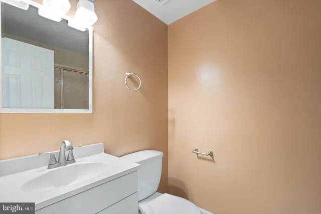 a bathroom with a sink mirror and toilet
