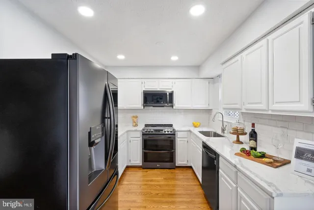 a kitchen with stainless steel appliances a refrigerator a stove a sink a microwave and cabinets
