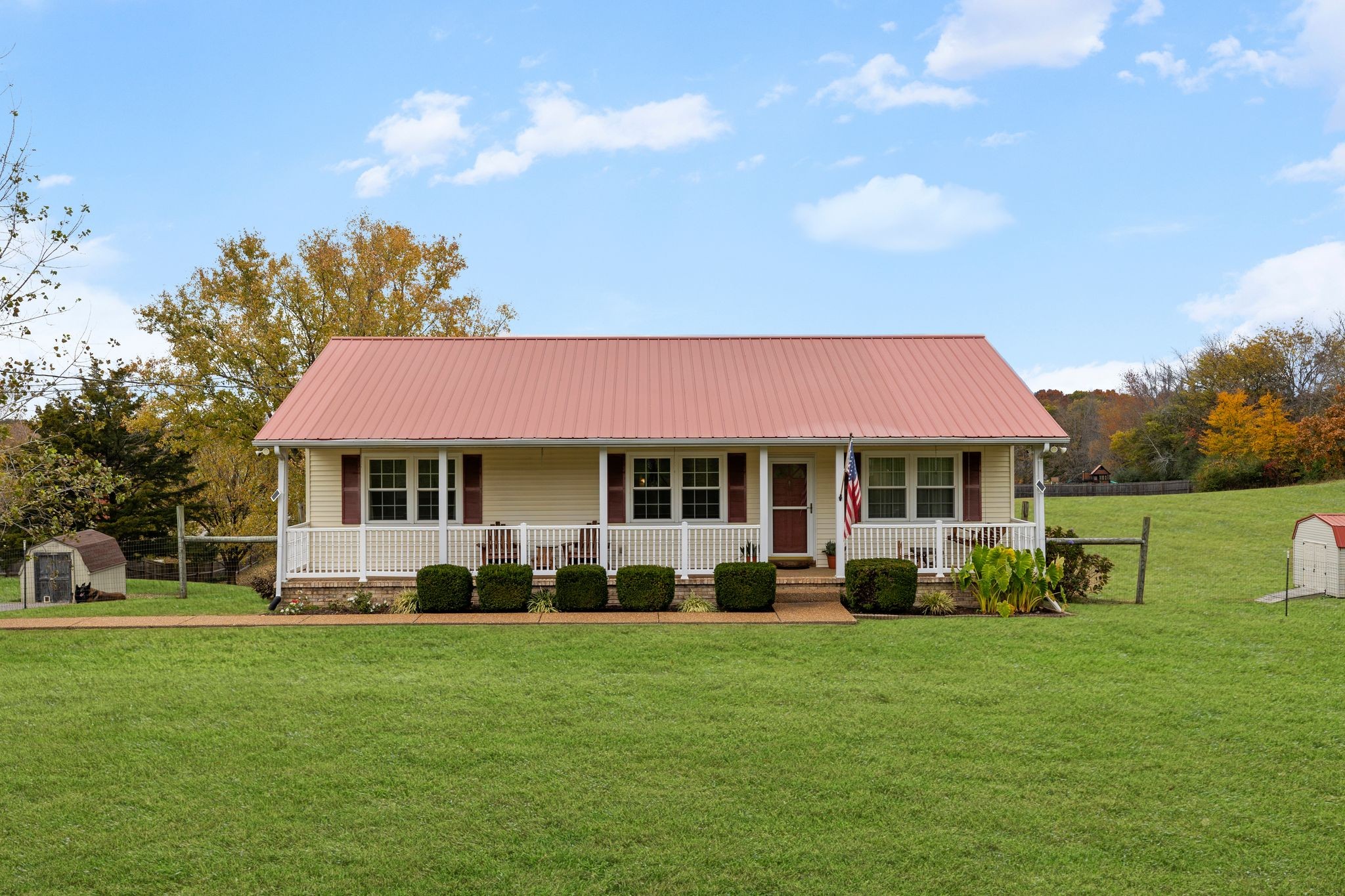 a front view of a house with a garden and trees