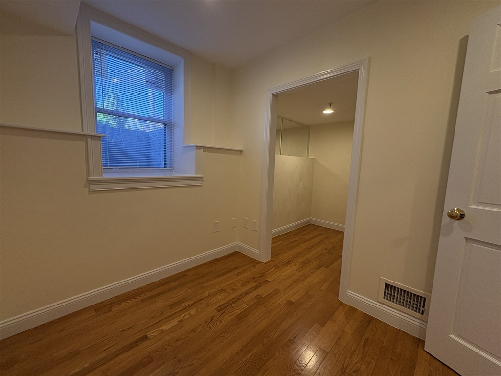 1801 Beacon Street, Unit 1 Brookline, MA 02445 - Photo 12 of 14 an empty room with wooden floor and windows