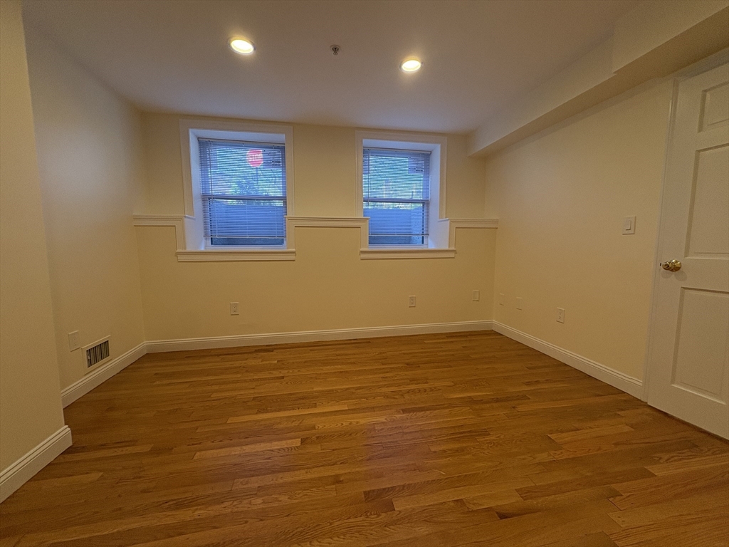 1801 Beacon Street, Unit 1 Brookline, MA 02445 - Photo 10 of 14 a view of an empty room with wooden floor and a window