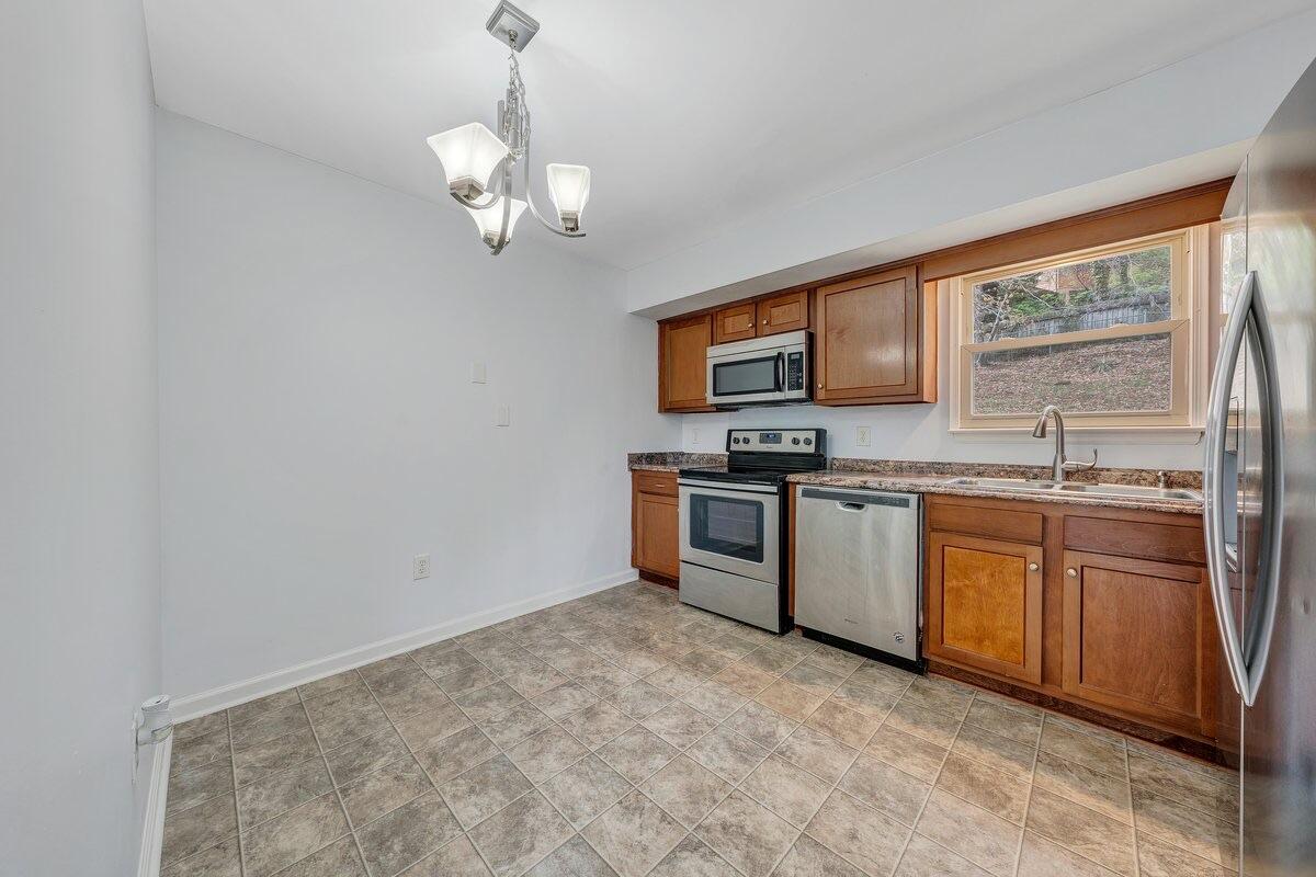 756 Kenyon Road Vinton, VA 24179 - Photo 10 of 14 a kitchen with stainless steel appliances granite countertop a stove a sink and a microwave