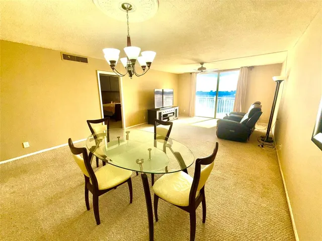 a view of a dining room with furniture and chandelier
