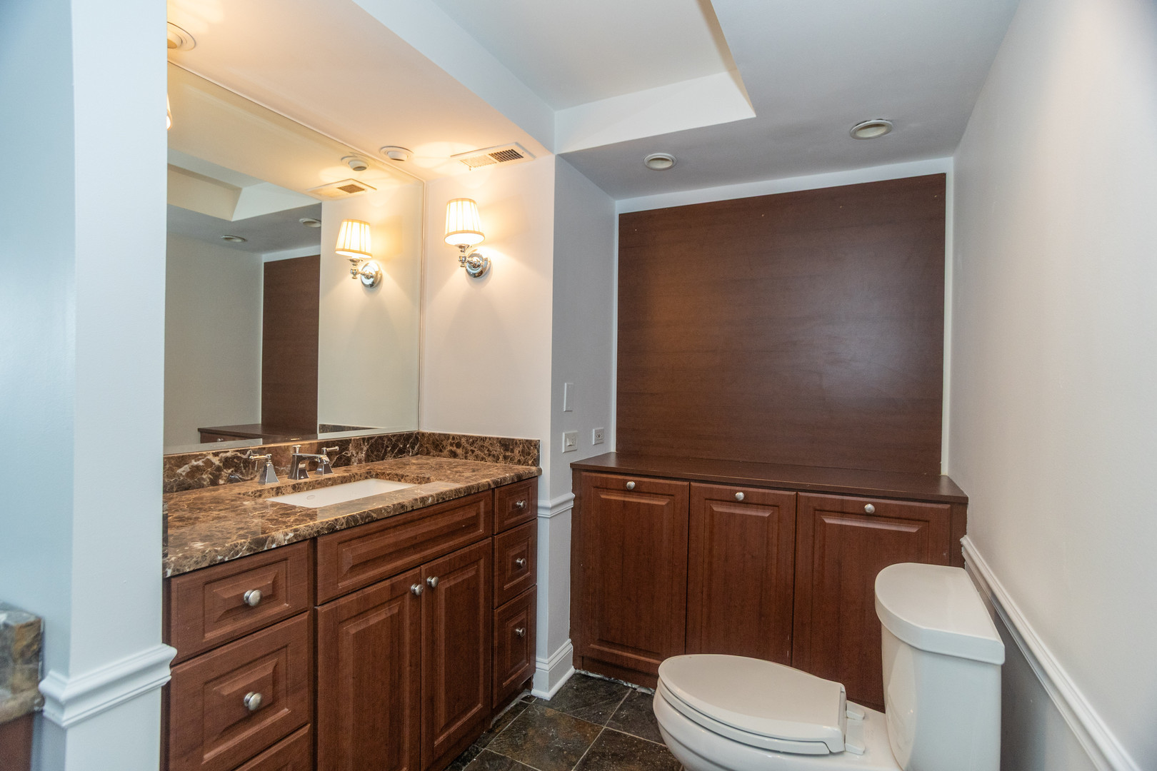 1440 North Lake Shore Drive, Unit 22ABCD Chicago, IL 60610 - Photo 18 of 21 a bathroom with a granite countertop toilet sink and mirror