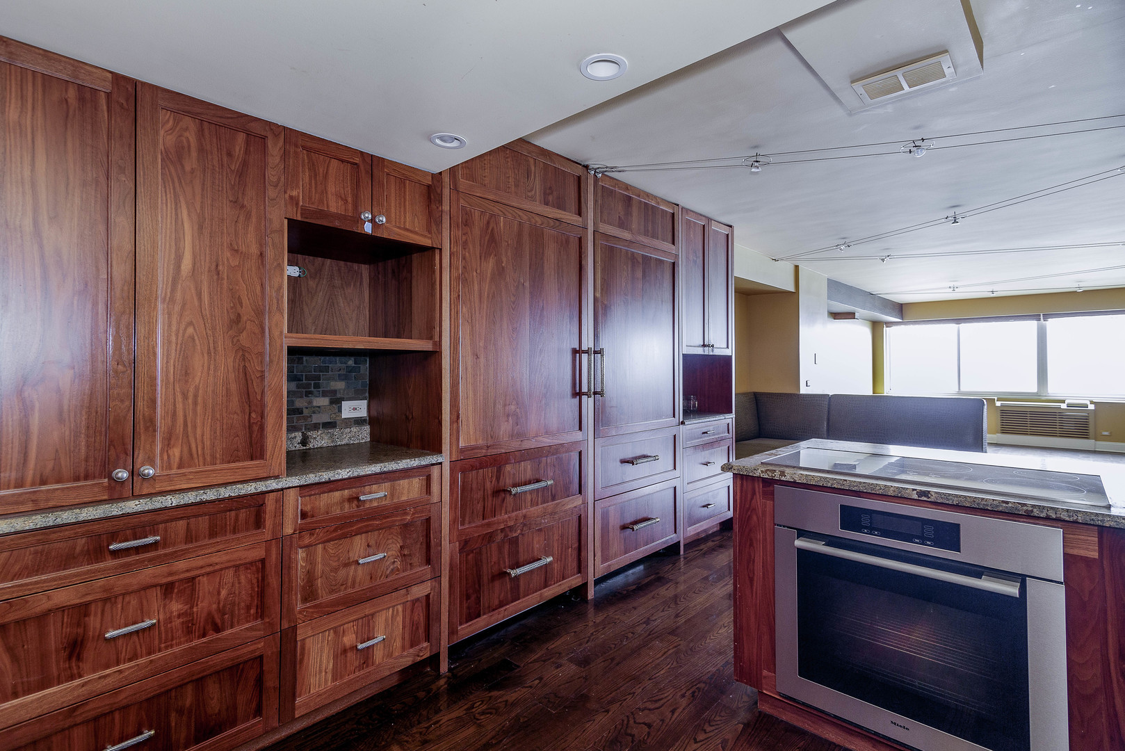 1440 North Lake Shore Drive, Unit 22ABCD Chicago, IL 60610 - Photo 5 of 21 a kitchen with granite countertop wooden cabinets and stainless steel appliances