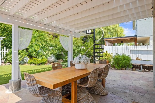 a view of a patio with table and chairs potted plants with floor to ceiling window