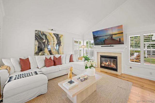 a living room with furniture a flat screen tv and a fireplace
