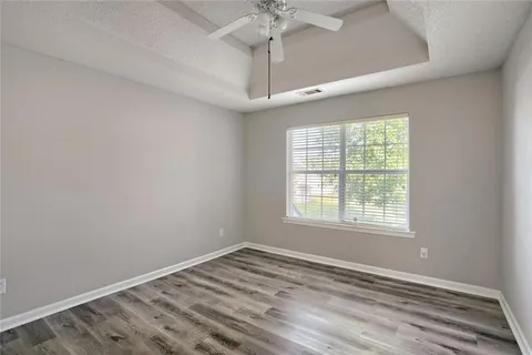 an empty room with a window and a chandelier fan