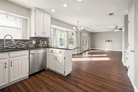 a kitchen with granite countertop a sink and cabinets