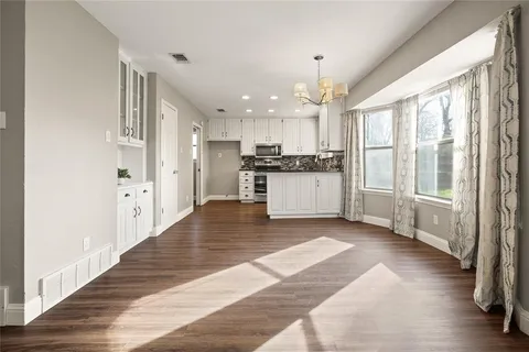a view of a kitchen with kitchen island granite countertop a refrigerator stove top oven and sink