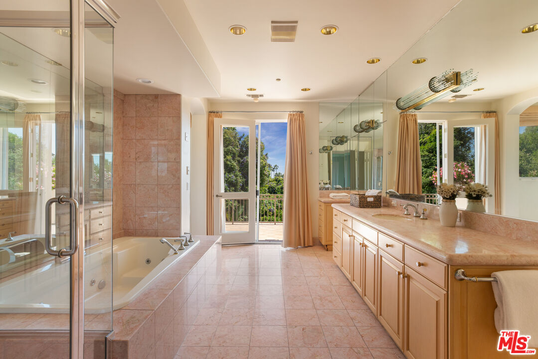510 Doheny Road Beverly Hills, CA 90210 - Photo 18 of 24 a large bathroom with a tub a double vanity sink a mirror and a shower