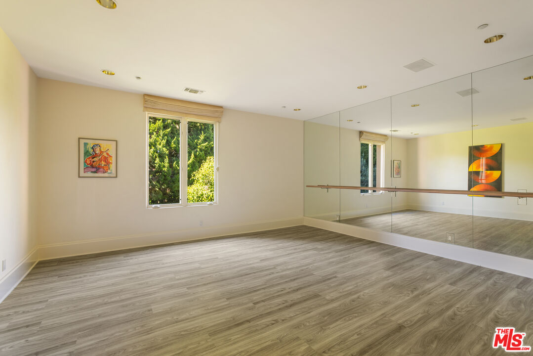 510 Doheny Road Beverly Hills, CA 90210 - Photo 22 of 24 a view of an empty room with window and wooden floor