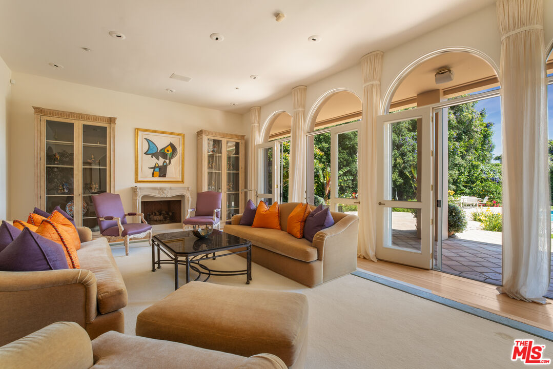 510 Doheny Road Beverly Hills, CA 90210 - Photo 4 of 24 a living room with furniture fireplace and a large window