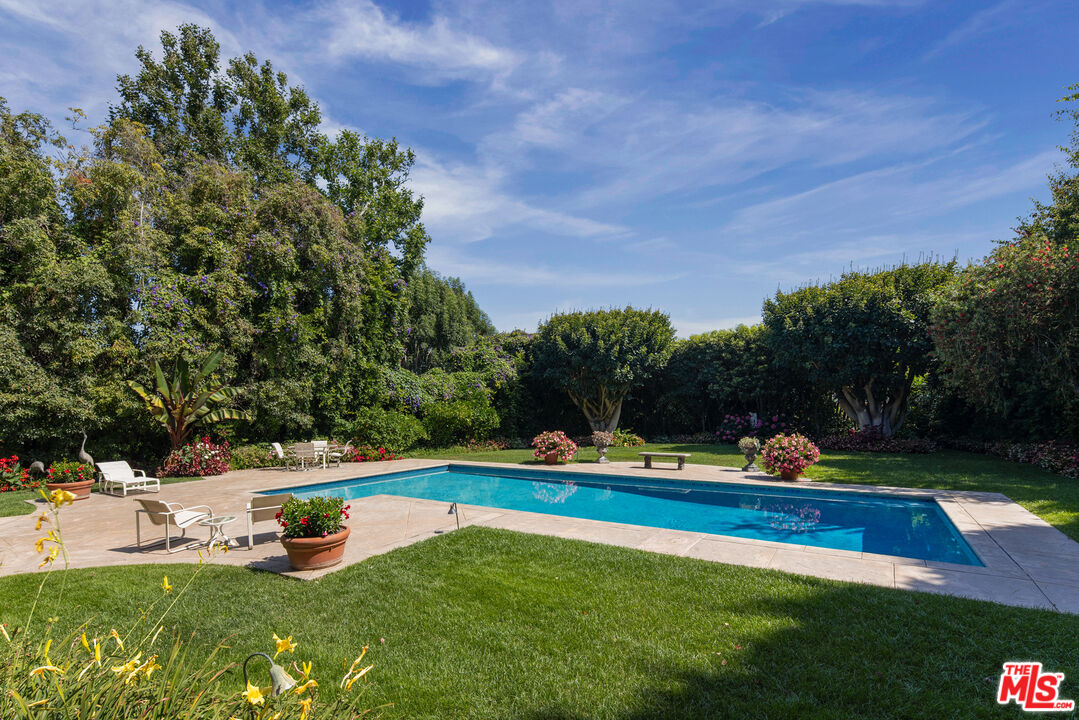 510 Doheny Road Beverly Hills, CA 90210 - Photo 7 of 24 a view of a swimming pool with lawn chairs and plants