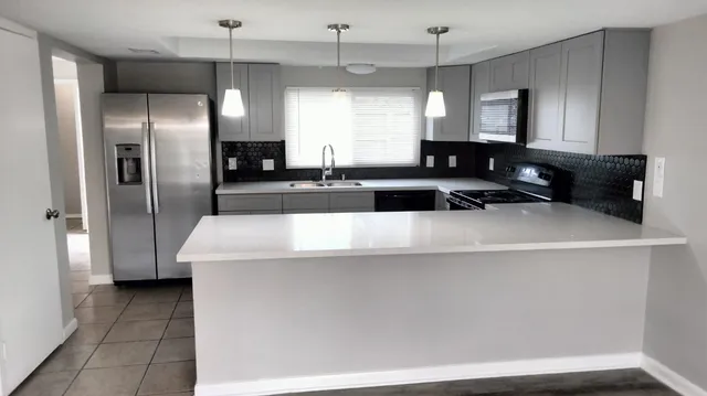a kitchen with stainless steel appliances a refrigerator sink and stove