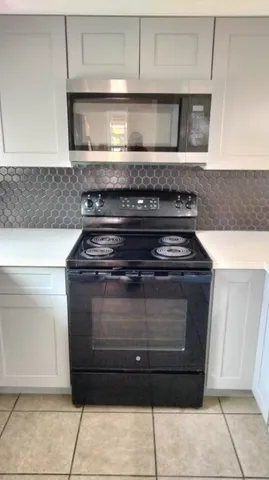 a stove top oven sitting inside of a kitchen
