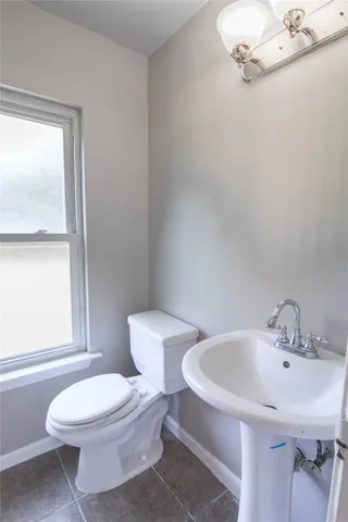 a white toilet sitting next to a bathroom sink