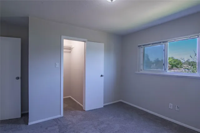 an empty room with windows and closet