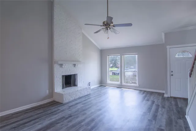 a view of an empty room with a window and fireplace