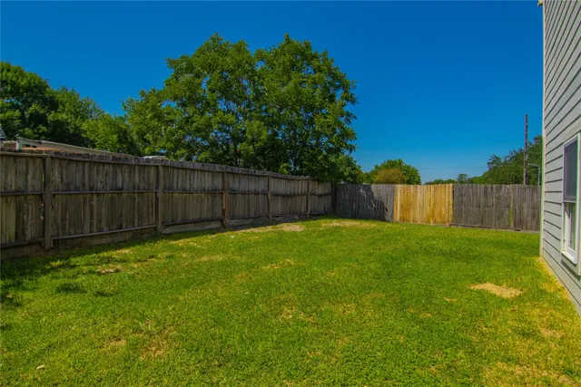 a view of a backyard with wooden fence