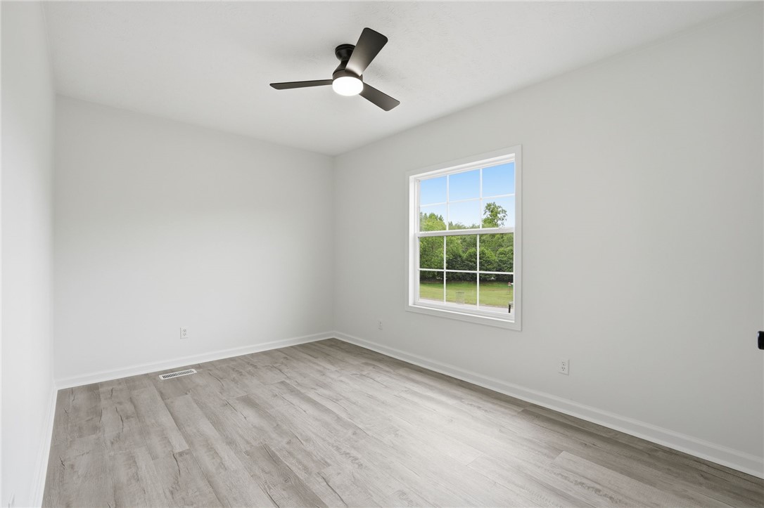 112 Sir Francis Drake Way Liberty, SC 29657 - Photo 25 of 42 This bright bedroom features a window overlooking lush greenery and durable plank flooring.