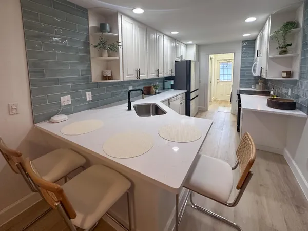 a kitchen with white cabinets and sink
