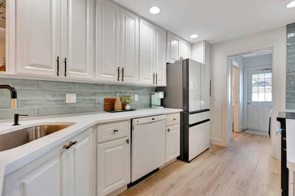 a kitchen with a sink a refrigerator and cabinets