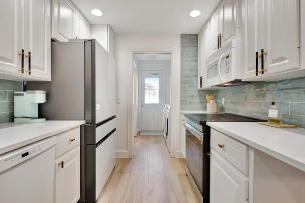 a kitchen with stainless steel appliances white cabinets and a sink