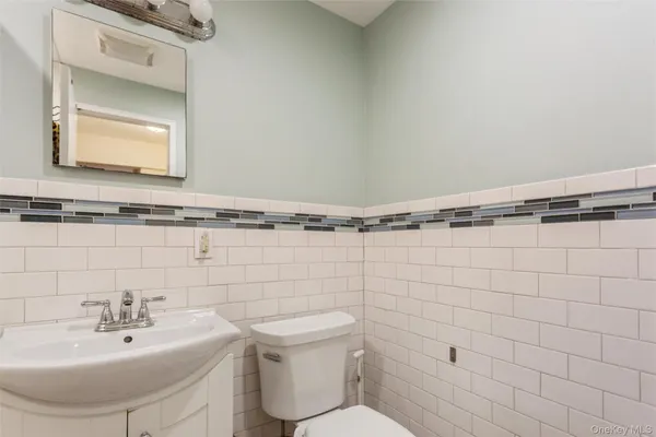 a bathroom with a sink mirror and toilet