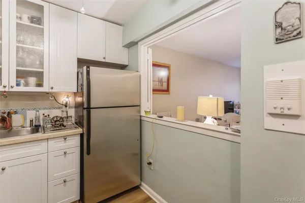 a kitchen with a refrigerator sink and cabinets